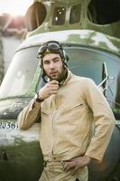 Young pilot posing near the helicopter photo