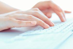 Female hands or woman office worker typing on the keyboard photo