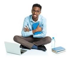 contento africano americano Universidad estudiante con computadora portátil, libros y botella de agua sentado en blanco foto