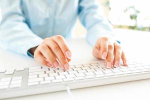 Woman office worker typing on the keyboard photo