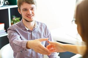 Businessman and businesswoman shaking hands in office photo