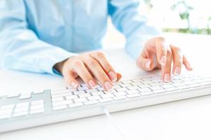 Woman office worker typing on the keyboard photo