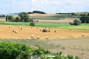 harvested fields with a tractor photo