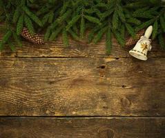 Christmas tree branches with cones and christmas decorations on wooden texture ready for your design photo