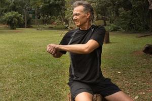 Mature Man outside at a local park doing Stretches before working out photo