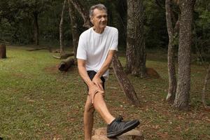 Mature Man outside at a local park doing Stretching his leg before working out photo