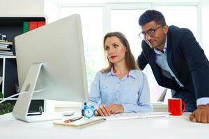 Beautiful young woman and man working from home office photo