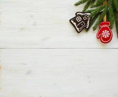 Christmas tree branches with christmas decorations on white wooden texture ready for your design photo