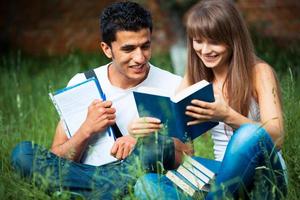Two students studying in park on grass photo