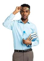 African american college student with books and bottle of water in his hands standing on white photo