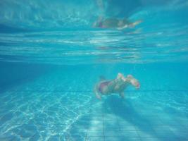 Beard man with glasses diving in a pool photo