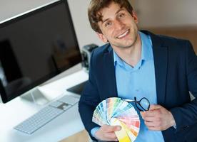 Young man looking to a color paint palette photo