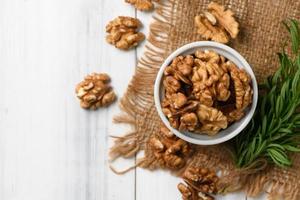 Top view of Walnut in white cup on wood background. photo