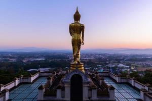 Big golden buddha statue standing in Wat Phra That Kao Noi photo