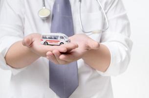 ambulancia modelo en médico mano aislado en blanco fondo, seguro concepto foto