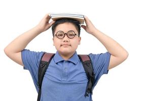 smart asian obese boy wearing glasses and hold a piles of books over his head photo