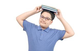 Portrait of Obese schoolboy holding a book above his head. Isolated background. photo