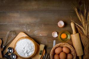 Bread flour with fresh egg and accessories bakery on wood background, photo