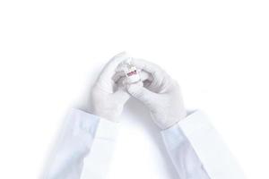 Doctor or scientist hand in white gloves holding COVID-19 vaccine photo