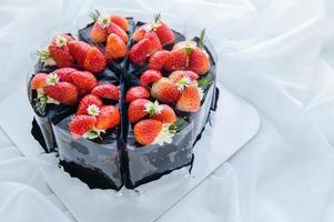 Chocolate cake decorated with fresh strawberry on white cloth, photo