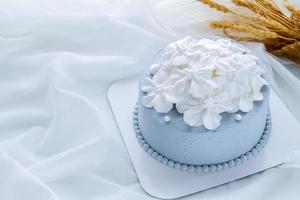 Pastel blue coconut cake decorated with white flowers from fresh cream photo