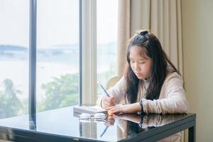 Cute girl sits and writes a travel diary in a hotel room. travel concept photo