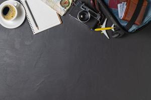 Prepare a suitcase,  vintage camera,  notebook, map and black coffee photo