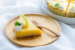 Lemon Tart citrus cake in wood dish and white cloth background, photo