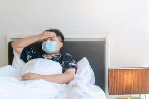 Unhappy little boy feel unwell with virus or cold illness, having headache, measures the body temperature photo