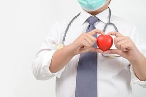 young doctor holding a red heart isolated on white background, heart health, photo