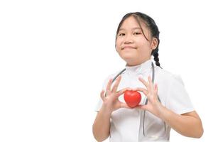cute little girl doctor holding a red heart isolated on white background, photo
