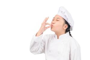 Cute chef girl showing sign for delicious. photo