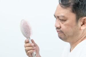 de edad mediana hombre muestra peine cepillo con pérdida pelo y estresado acerca de su pelo pérdida problemas foto