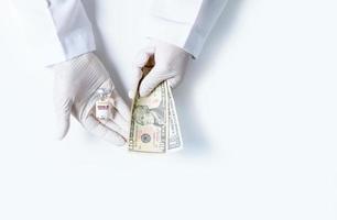 Scientists wear rubber gloves carrying COVID-19 vaccine bottles and us dollars isolated photo