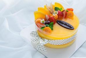 Orange cake with happy birth day and topped with orange, strawberry, blueberry and Cape Gooseberry photo