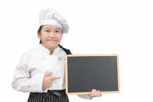 Little asian girl chef in uniform cook holding blackboard for in put text or menu photo