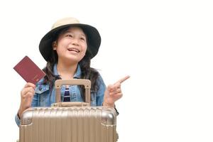 Cute asian kid ready to travel wearing a hat and holding her passport with luggage photo