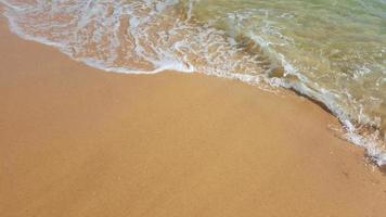 dorado arena lavados el calentar mar en un soleado día. foto