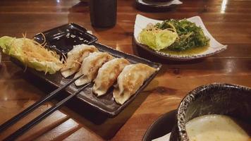 Gyoza lightly fried. Soy sauce and vegetables. photo