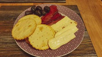 rebanado carne y queso, aceitunas y galletas foto