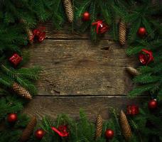 Christmas tree branches with cones and christmas decorations on wooden texture ready for your design photo