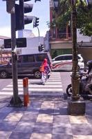 surabaya, indonesia, 2022 - street view with people crossing on zebra crossing photo