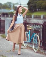 Young beautiful, elegantly dressed woman with bicycle photo