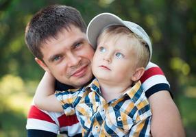 padre y su bebé hijo teniendo divertido en el parque al aire libre foto