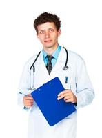 Portrait of young male doctor writing on a patient's medical chart on white photo