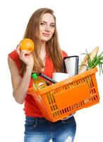 Happy young woman holding a basket full of healthy food on white. Shopping photo