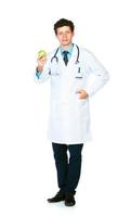 Portrait of a male doctor holding green apple on white photo