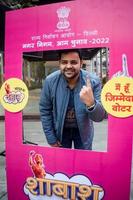 New Delhi, India - December 04 2022 - Unidentified people showing their ink-marked fingers after casting votes in front of polling booth of east Delhi area for MCD local body Elections 2022 photo
