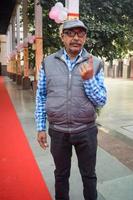 New Delhi, India - December 04 2022 - Unidentified people showing their ink-marked fingers after casting votes in front of polling booth of east Delhi area for MCD local body Elections 2022 photo