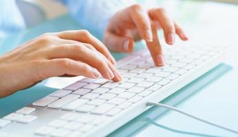 Woman office worker typing on the keyboard photo